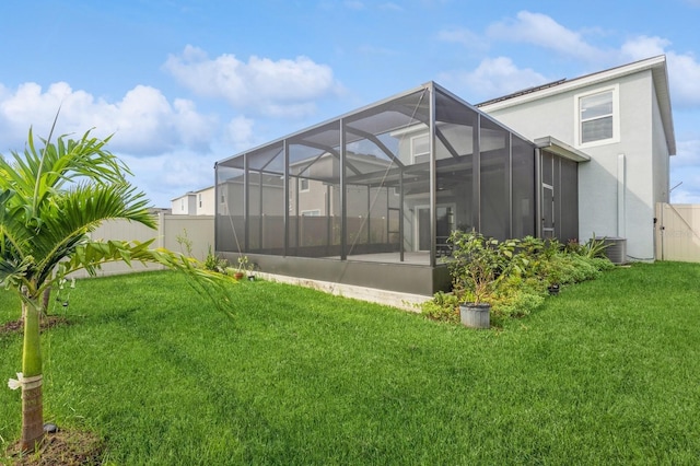 back of house with a lanai, a lawn, and central air condition unit