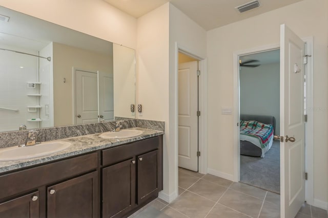 bathroom with tile patterned flooring, vanity, and a shower