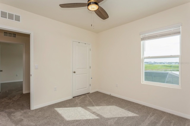 spare room with ceiling fan and carpet