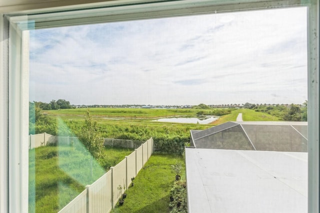 view of yard with a water view, a rural view, and glass enclosure