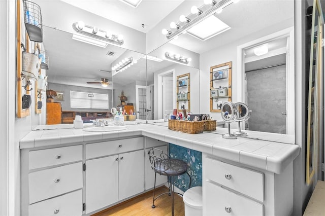 bathroom featuring ceiling fan, hardwood / wood-style flooring, and vanity