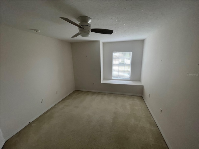 unfurnished room with a textured ceiling, ceiling fan, and light colored carpet