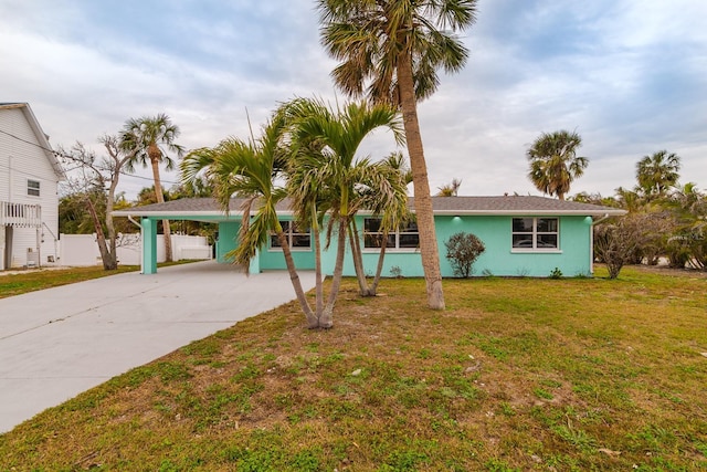 single story home featuring a front lawn and a carport