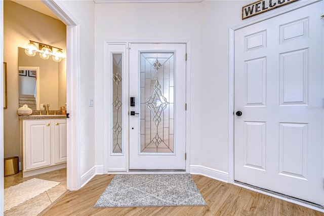 foyer entrance with sink and light wood-type flooring