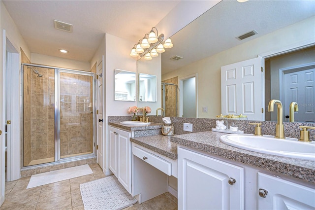 bathroom featuring tile patterned flooring, an enclosed shower, and vanity