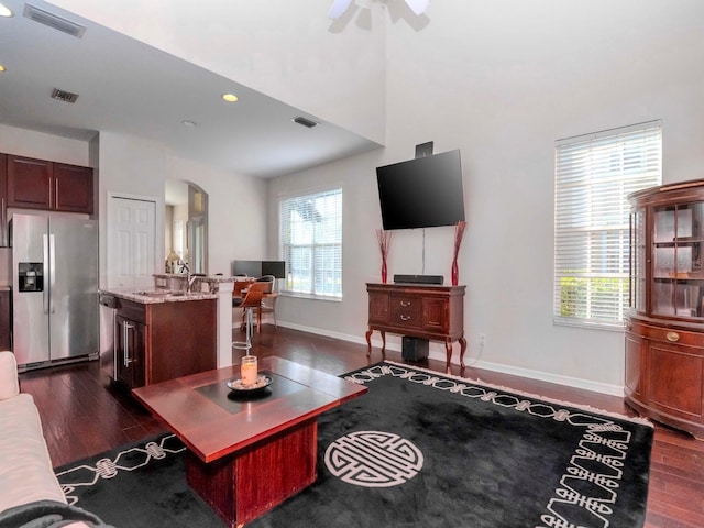 living room featuring ceiling fan, dark hardwood / wood-style floors, and sink