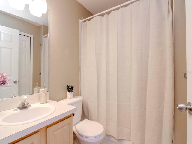 bathroom featuring vanity, toilet, and curtained shower