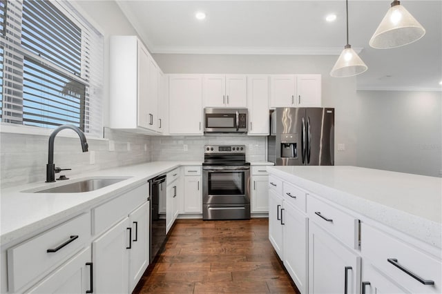 kitchen featuring appliances with stainless steel finishes, sink, decorative light fixtures, backsplash, and white cabinets