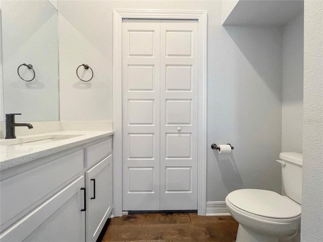 bathroom with vanity, toilet, and hardwood / wood-style floors