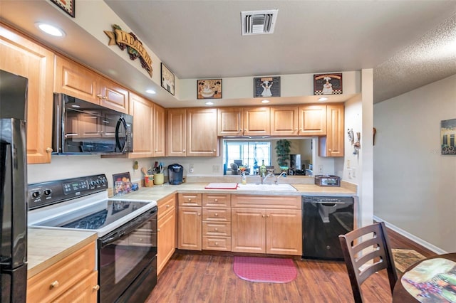 kitchen featuring a textured ceiling, black appliances, dark wood-type flooring, light brown cabinetry, and sink