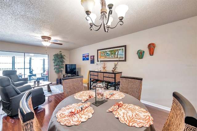 dining room with dark hardwood / wood-style floors, ceiling fan with notable chandelier, and a textured ceiling