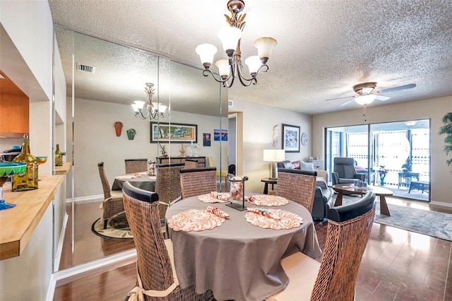 dining space with ceiling fan with notable chandelier, a textured ceiling, and hardwood / wood-style floors