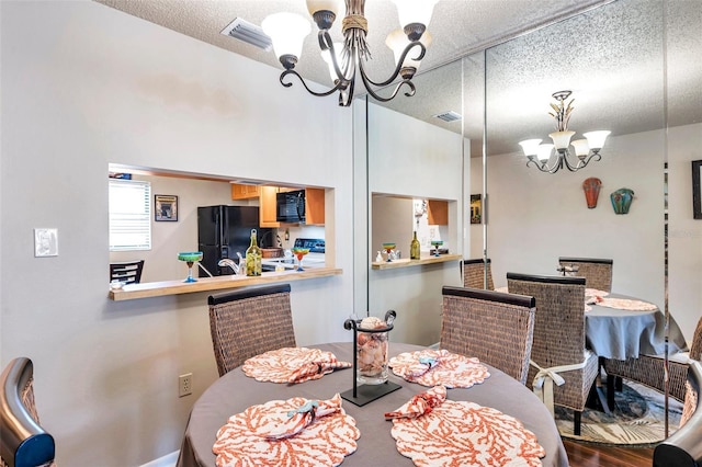 dining space with a textured ceiling and an inviting chandelier