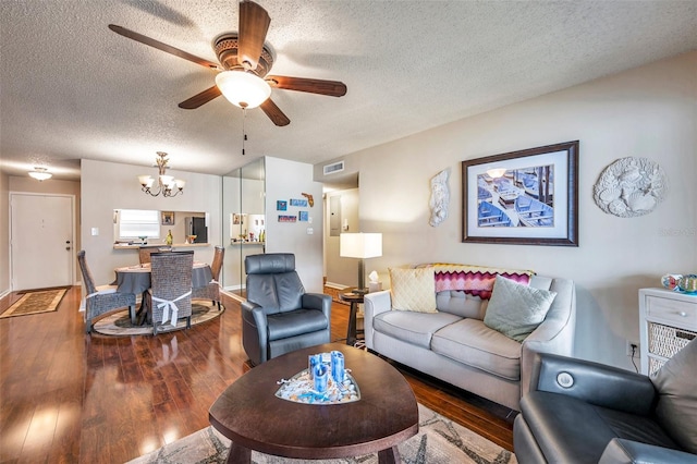 living room featuring hardwood / wood-style flooring, a textured ceiling, and ceiling fan with notable chandelier