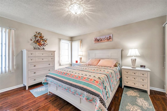 bedroom with dark wood-type flooring and a textured ceiling