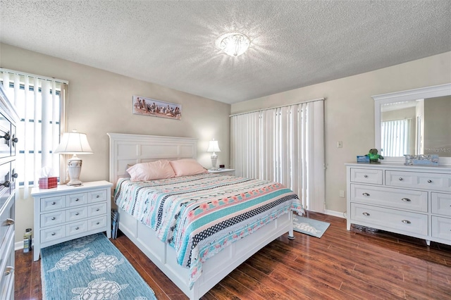 bedroom featuring a textured ceiling and dark wood-type flooring