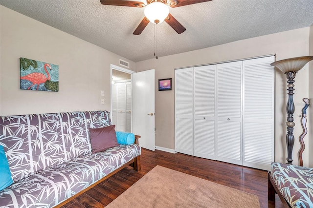 living room with ceiling fan, wood-type flooring, and a textured ceiling