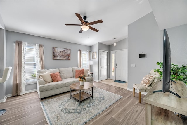 living room featuring lofted ceiling, a wealth of natural light, and light hardwood / wood-style floors