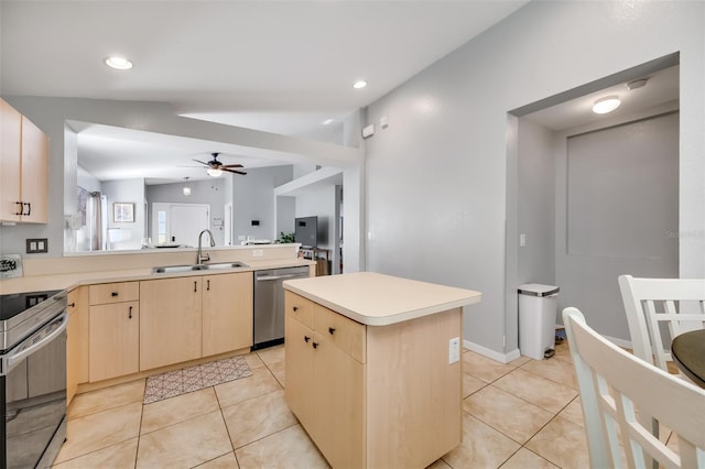 kitchen featuring vaulted ceiling, a center island, sink, appliances with stainless steel finishes, and light brown cabinets