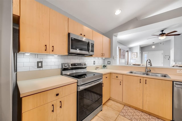 kitchen featuring light brown cabinetry, sink, appliances with stainless steel finishes, and lofted ceiling