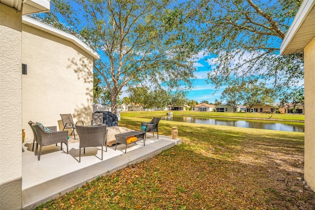 view of yard with a water view, a patio area, and outdoor lounge area