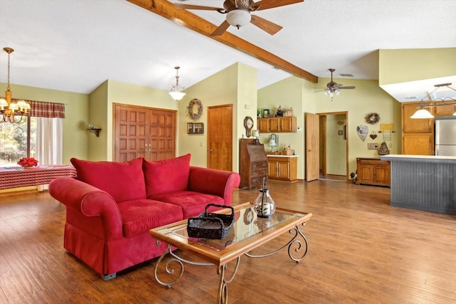 living room featuring vaulted ceiling with beams, wood-type flooring, and ceiling fan with notable chandelier