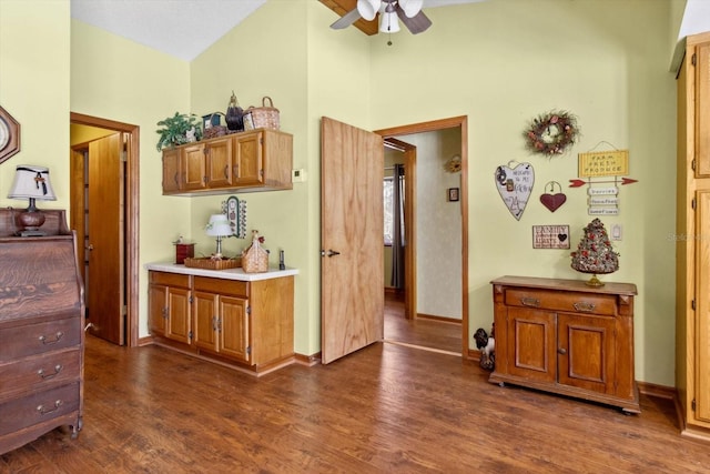 kitchen with dark wood-type flooring, high vaulted ceiling, and ceiling fan