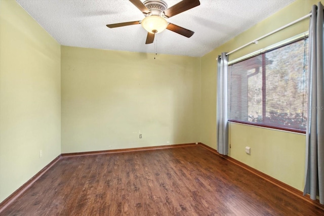 empty room featuring ceiling fan, a textured ceiling, and dark hardwood / wood-style floors