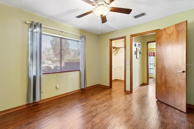 empty room with ceiling fan, hardwood / wood-style floors, and a textured ceiling