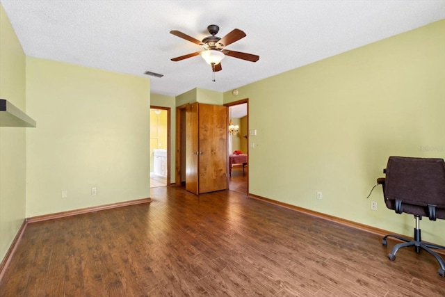 unfurnished office featuring a textured ceiling, dark wood-type flooring, and ceiling fan