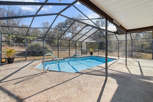 view of pool with glass enclosure and a patio