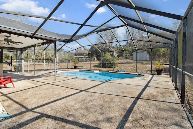 view of pool with a lanai, a storage shed, ceiling fan, and a patio area