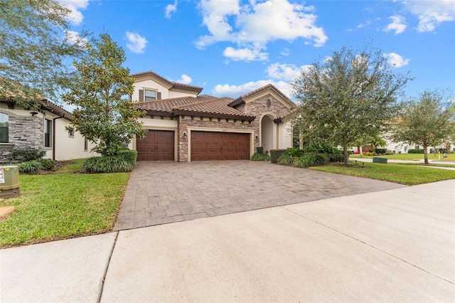 mediterranean / spanish home with a front yard and a garage