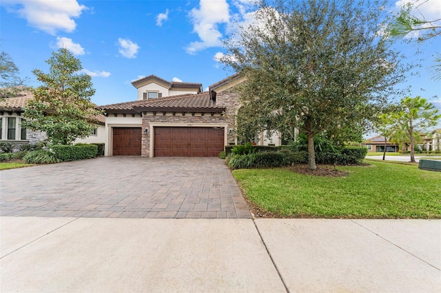 mediterranean / spanish house featuring a garage and a front lawn