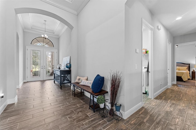 foyer entrance with a notable chandelier, ornamental molding, and french doors