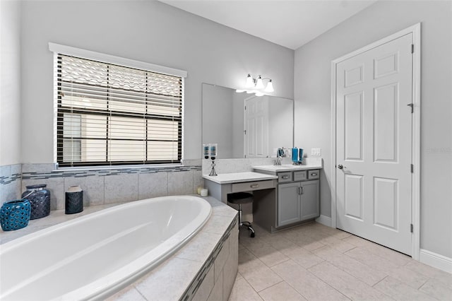 bathroom with tiled tub, tile patterned floors, and vanity