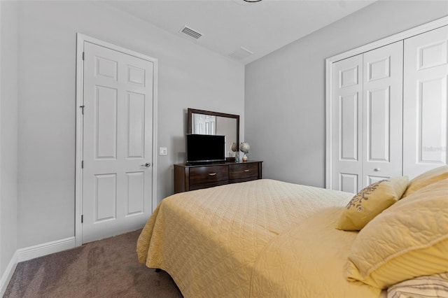 bedroom with a closet and dark carpet