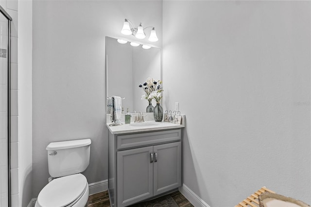 bathroom featuring toilet, vanity, and an enclosed shower