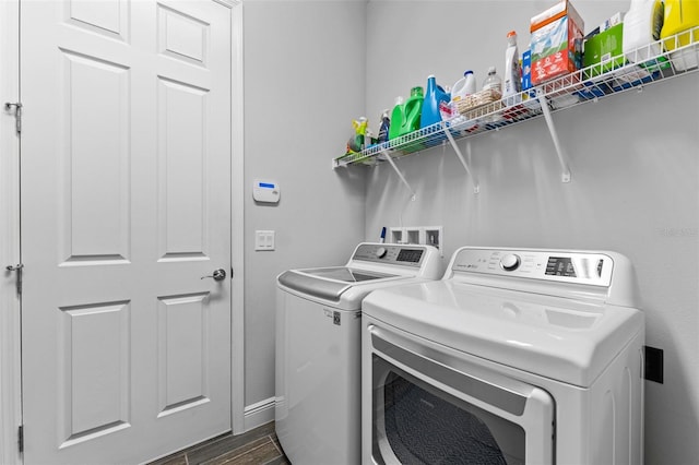 clothes washing area with dark wood-type flooring and washer and dryer