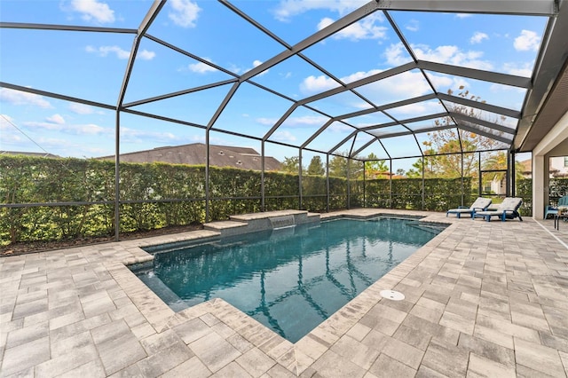 view of pool with glass enclosure and a patio