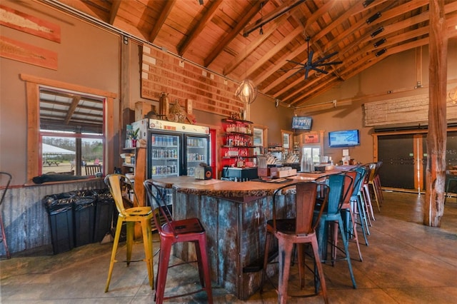 bar with high vaulted ceiling, beam ceiling, ceiling fan, and wooden ceiling