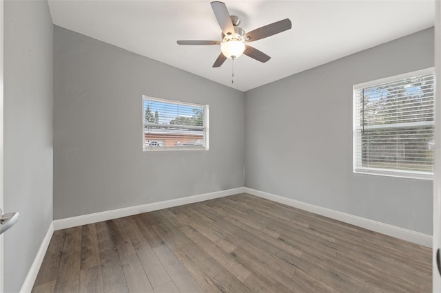 spare room with dark wood-type flooring, plenty of natural light, lofted ceiling, and ceiling fan