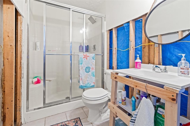 bathroom featuring toilet, sink, tile patterned floors, and a shower with shower door