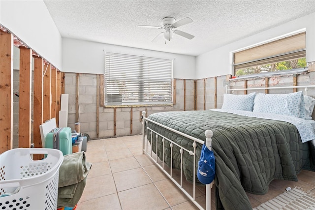 tiled bedroom featuring ceiling fan and a textured ceiling