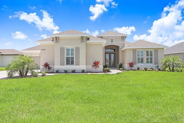 mediterranean / spanish-style home featuring french doors and a front yard