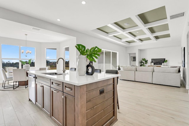 kitchen featuring sink, hanging light fixtures, a notable chandelier, an island with sink, and stainless steel dishwasher