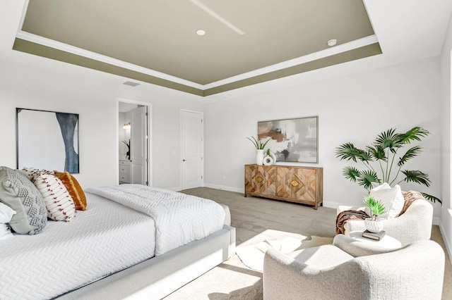 bedroom with light carpet, connected bathroom, ornamental molding, and a raised ceiling