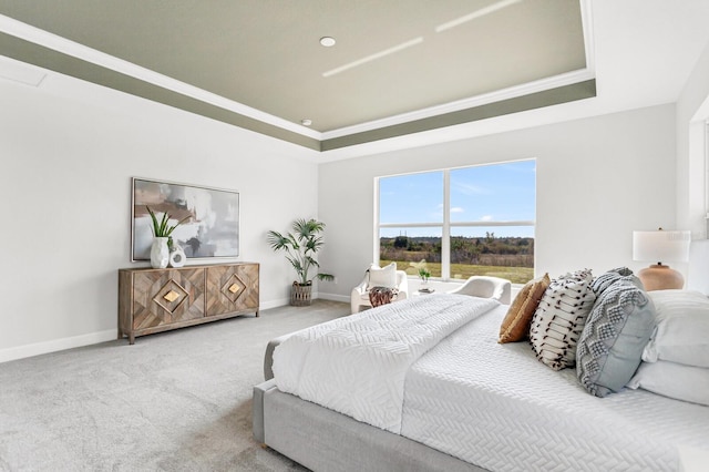 carpeted bedroom with a raised ceiling and crown molding