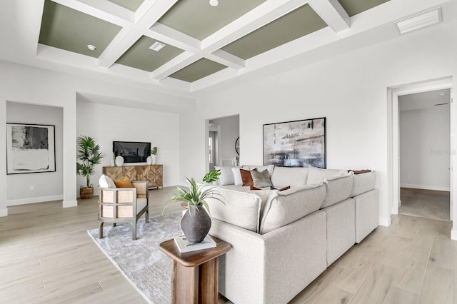 living room featuring coffered ceiling, light hardwood / wood-style floors, beam ceiling, and a high ceiling