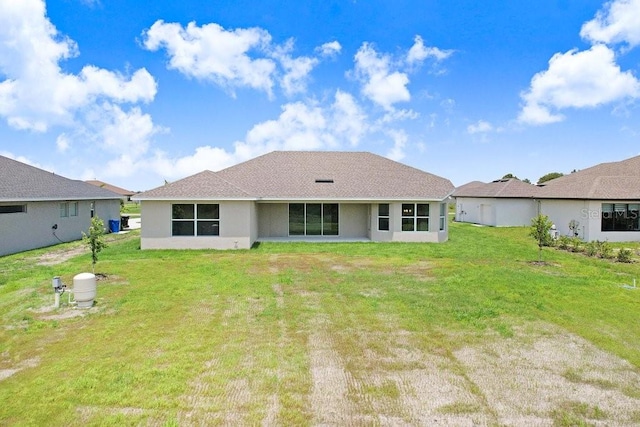 rear view of house featuring a yard